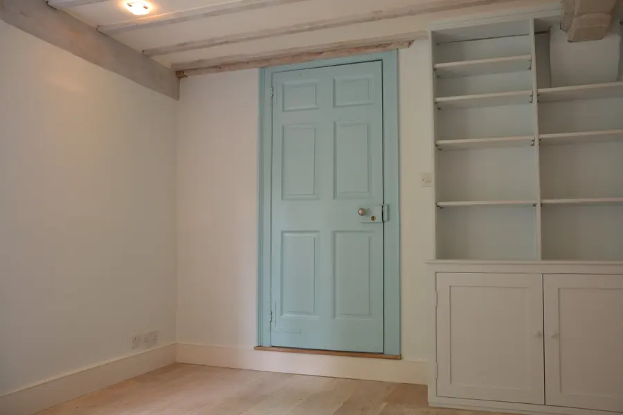 Duck-egg blue painted door beside painted built-in shelving