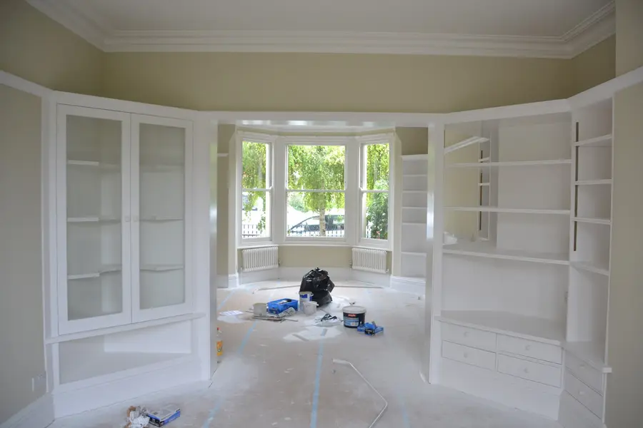 Finished study with built-in cabinetry painted white around the bay window
