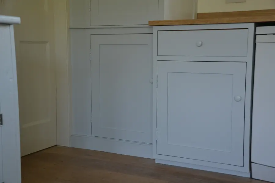 Resprayed base cabinet beside a painted larder door