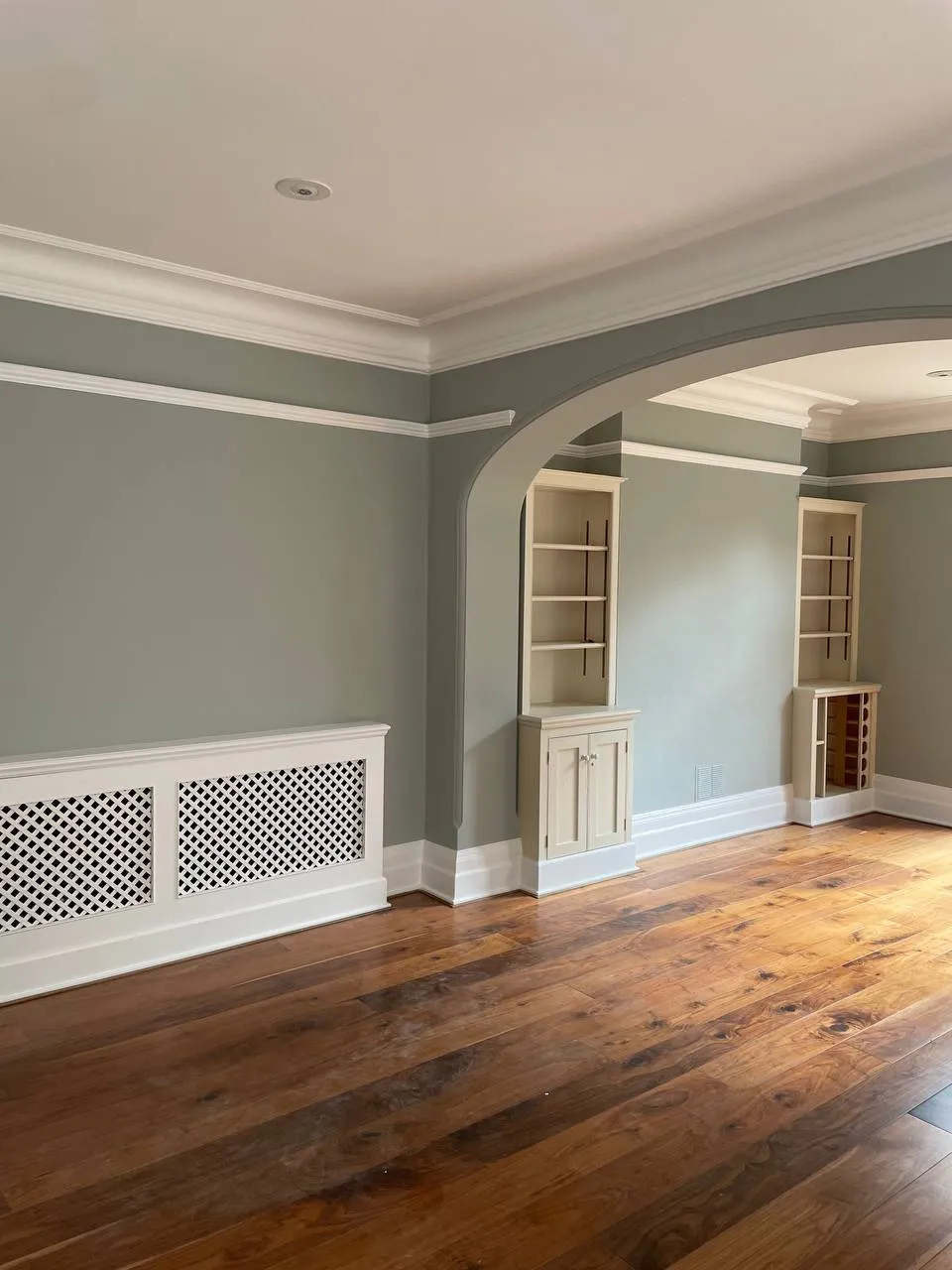 Green period room with a hand-painted radiator cabinet and panelling