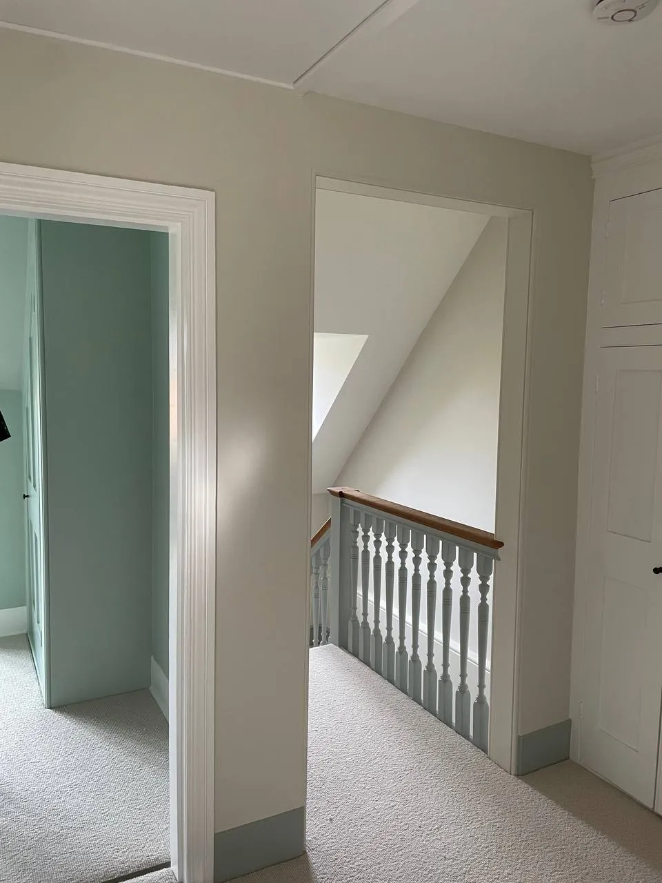 Period landing with a repainted balustrade leading to a mint-green room
