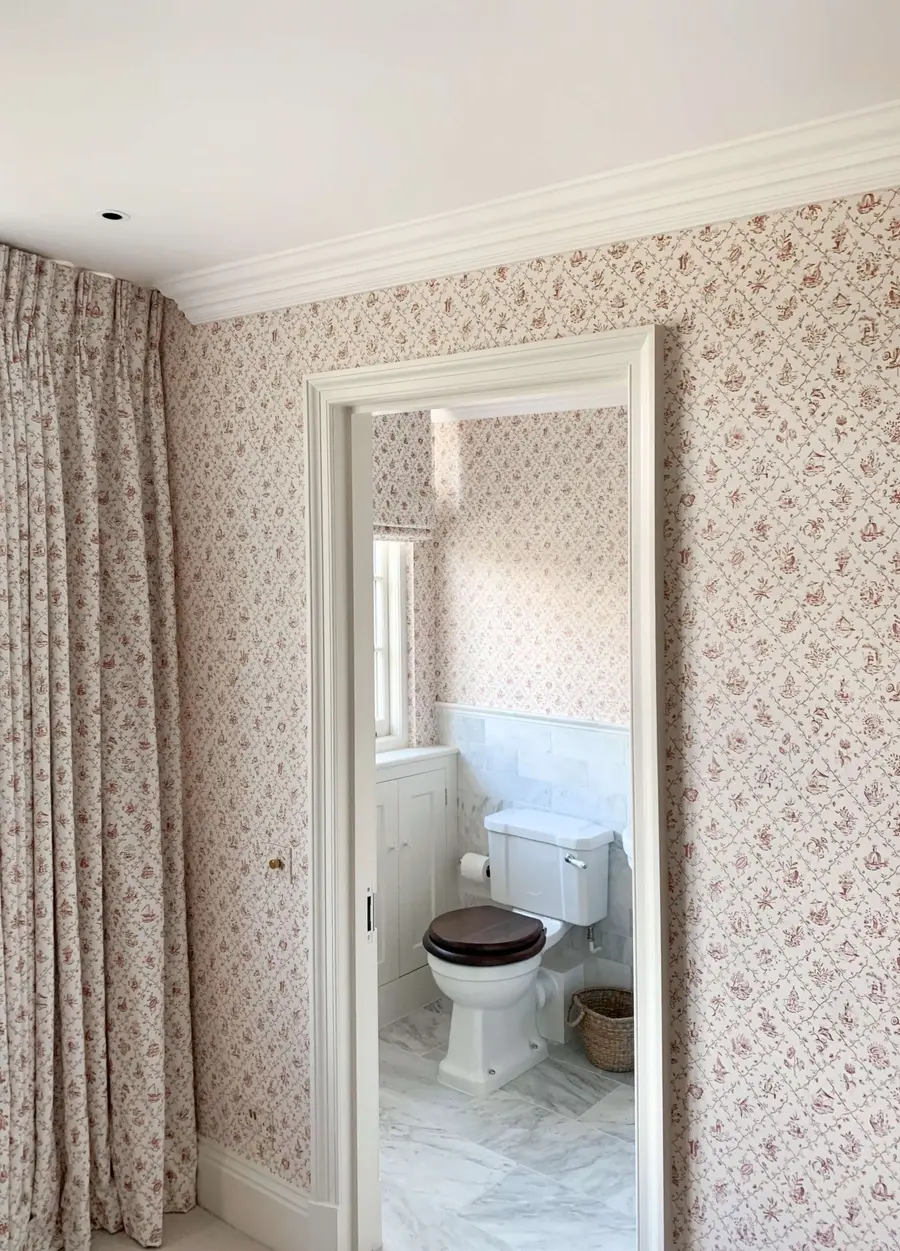 Floral wallpaper pattern-matched to the curtains and doorway