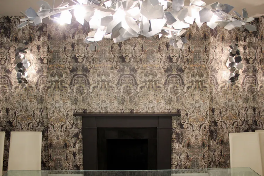 Damask wallpaper feature wall behind a fireplace